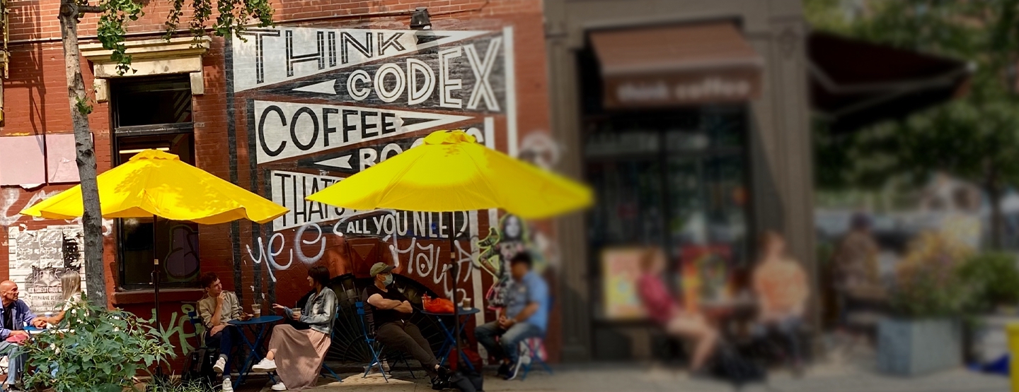 People sitting at tables with yellow umbrellas