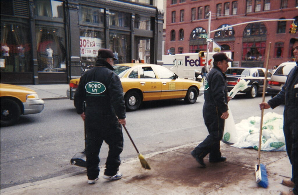 A photo of the NoHo BID clean team taking care of spilled debris by sweeping.